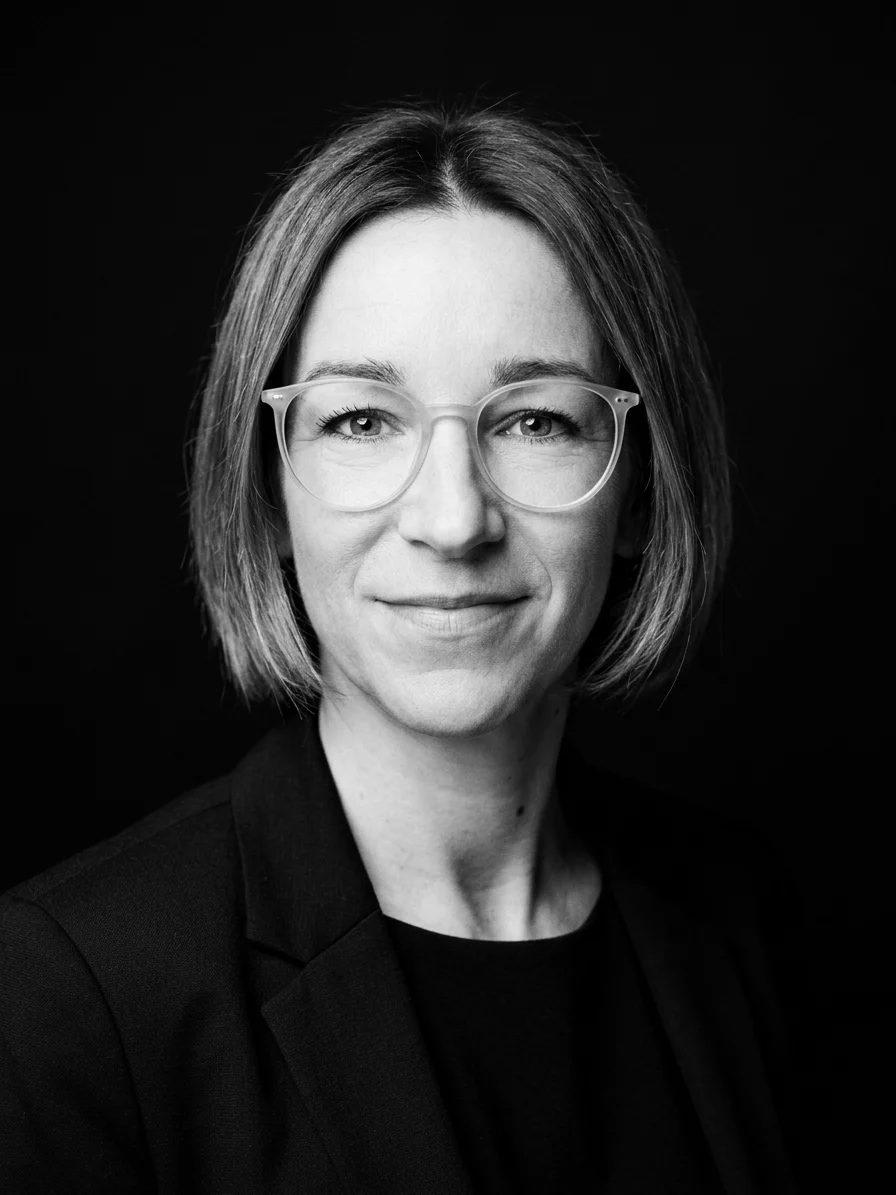 schwarz-weiß Porträt von Nicole Riegler, Studio Hintergrund schwarz, Geschäftsführerin von Visual Vision Grafik- und Webdesign